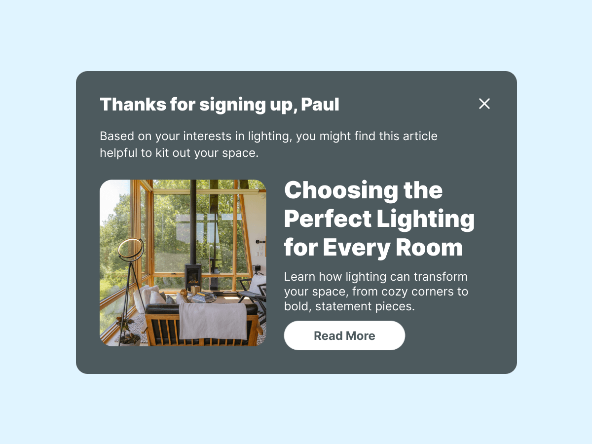 A pop-up message thanking a user named Paul for signing up, suggesting an article about choosing the perfect lighting for different rooms, with a brief description and a "Read More" button. The background is a light blue.